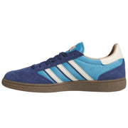 A low-top Adidas Busenitz sneaker in blue, featuring a suede and mesh upper, three white stripes, a light blue heel panel, and a brown gum sole.