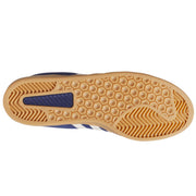 The outsole of a shoe, showing a tan gum rubber tread with a hexagonal pattern and a blue heel accent.
