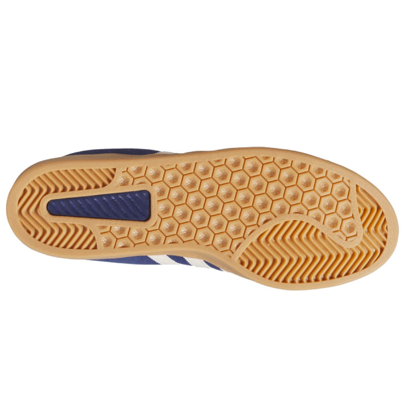 The outsole of a shoe, showing a tan gum rubber tread with a hexagonal pattern and a blue heel accent.