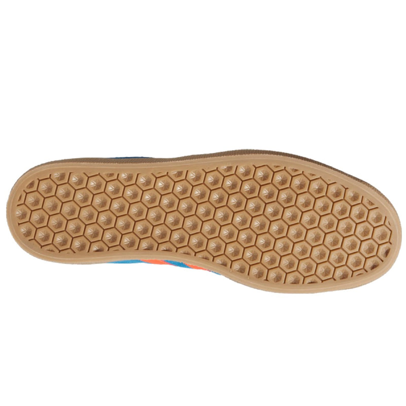 The bottom sole of a shoe, featuring a tan gum rubber base with a prominent hexagonal tread pattern.