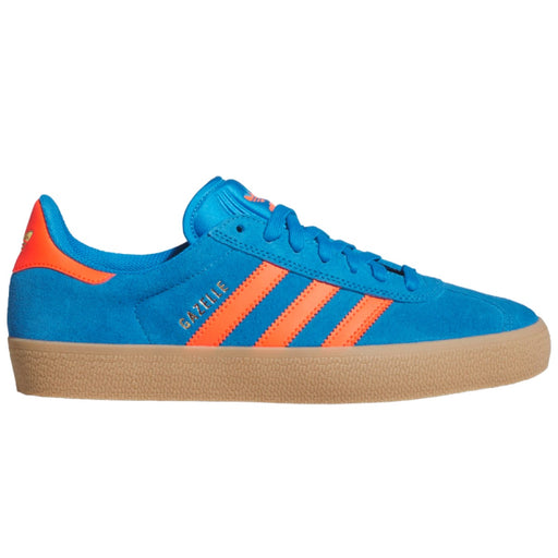 A blue suede Adidas Gazelle sneaker with bright orange stripes, a gum sole, and gold 'GAZELLE' text on the side.