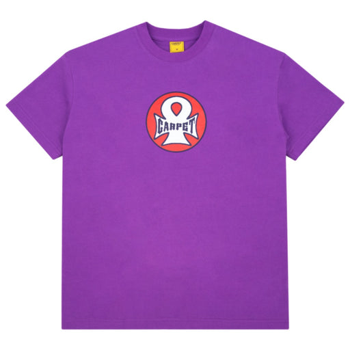A purple short-sleeve crewneck t-shirt featuring a circular chest graphic with a white stylized 'C' logo and the word 'CARPET' in white on a red and pink background.