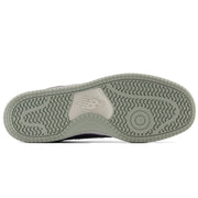 The outsole of a New Balance sneaker in a muted sage green color, showing the textured tread pattern and the embossed New Balance 'N' logo on a white background.