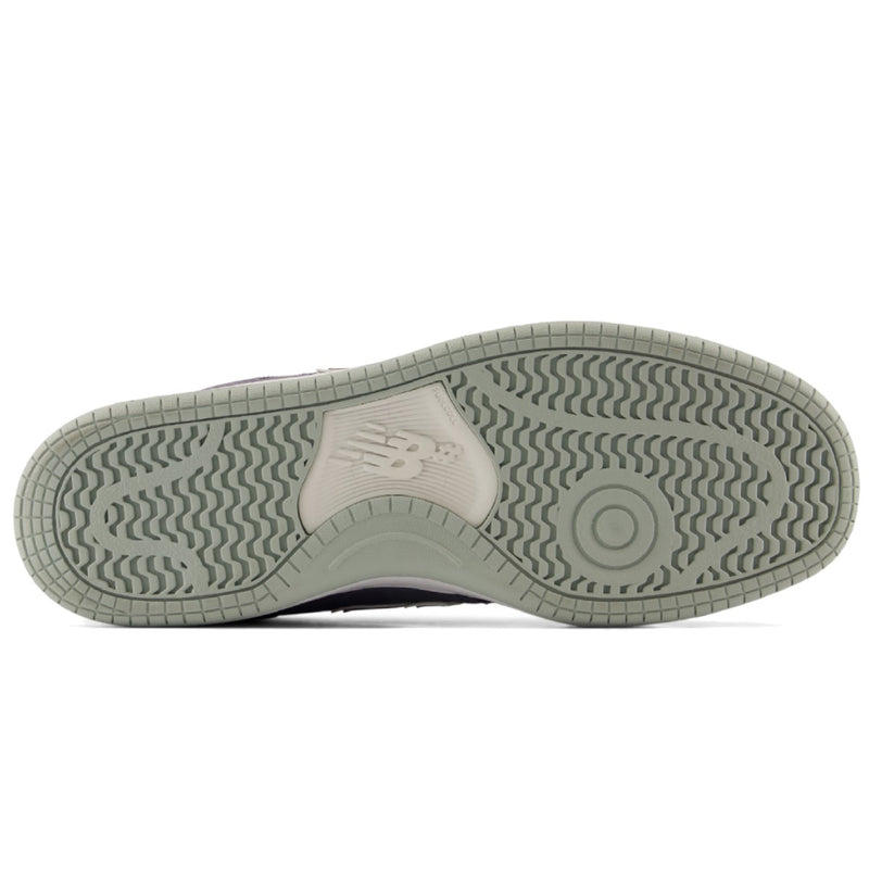 The outsole of a New Balance sneaker in a muted sage green color, showing the textured tread pattern and the embossed New Balance 'N' logo on a white background.