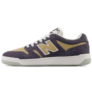 A New Balance sneaker in dark Grey suede and tan suede, featuring a white midsole and a light green outsole.