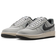  Nike SB Air Force 1 x Yuto sneakers in light gray and black, featuring a light gray leather and mesh upper, black Swoosh, and a beige midsole with a black outsole.