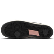 The bottom sole of a  Nike SB Air Force 1 x Yuto sneaker, featuring a black textured rubber outsole with a metallic pink heel tab.