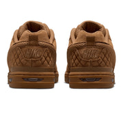 A pair of Nike low-top sneakers shown from the back, featuring a brown quilted suede and mesh upper with a matching brown sole.