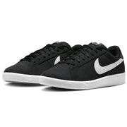 A pair of Nike low-top sneakers in black suede with a contrasting white Swoosh and white rubber sole.