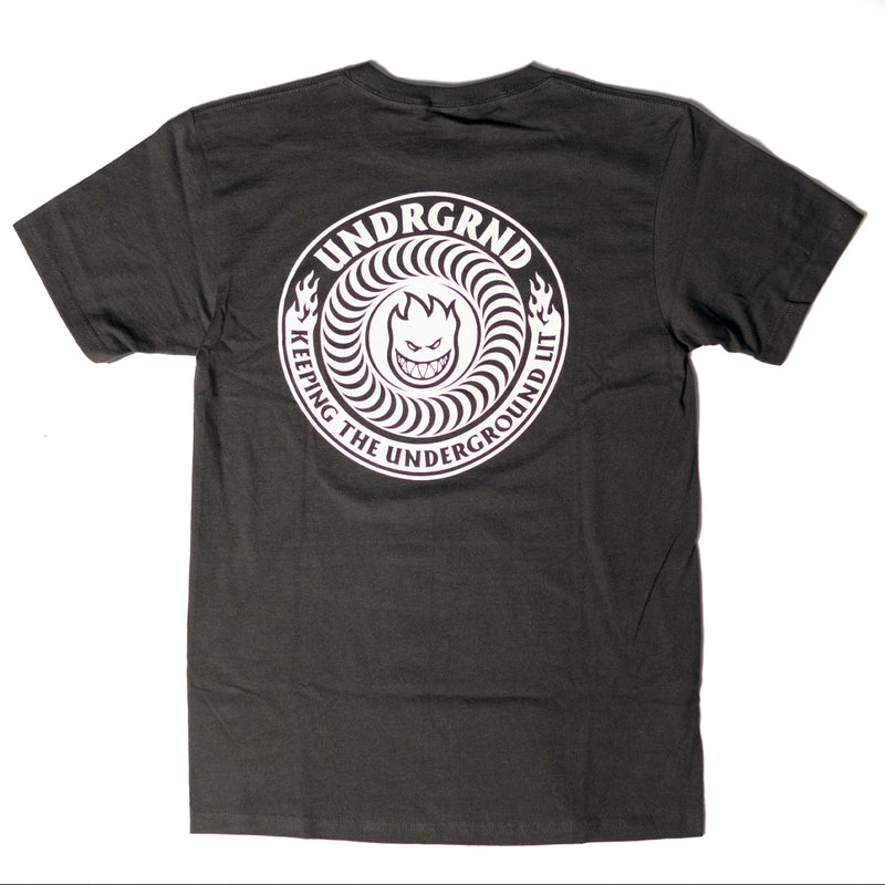 A black Spitfire t-shirt shown from the back, featuring a large white circular graphic print with the text 'UNDGRND' and 'KEEPING THE UNDERGROUND UNDERGROUND' surrounding a stylized face.